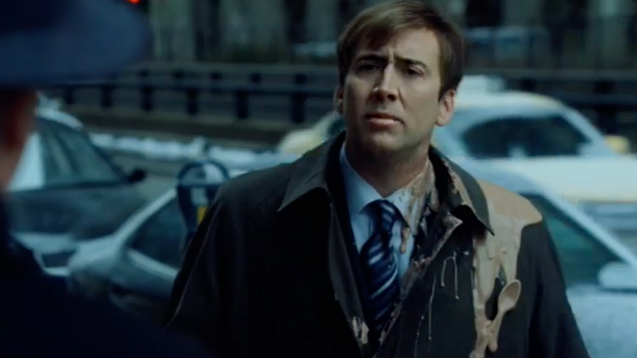 Nic Cage, on the streets of NYC, in a nice coat and tie, looking dejected and wearing a milkshake.