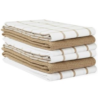 A pile of folded dish towels, alternating solid brown and white and brown check