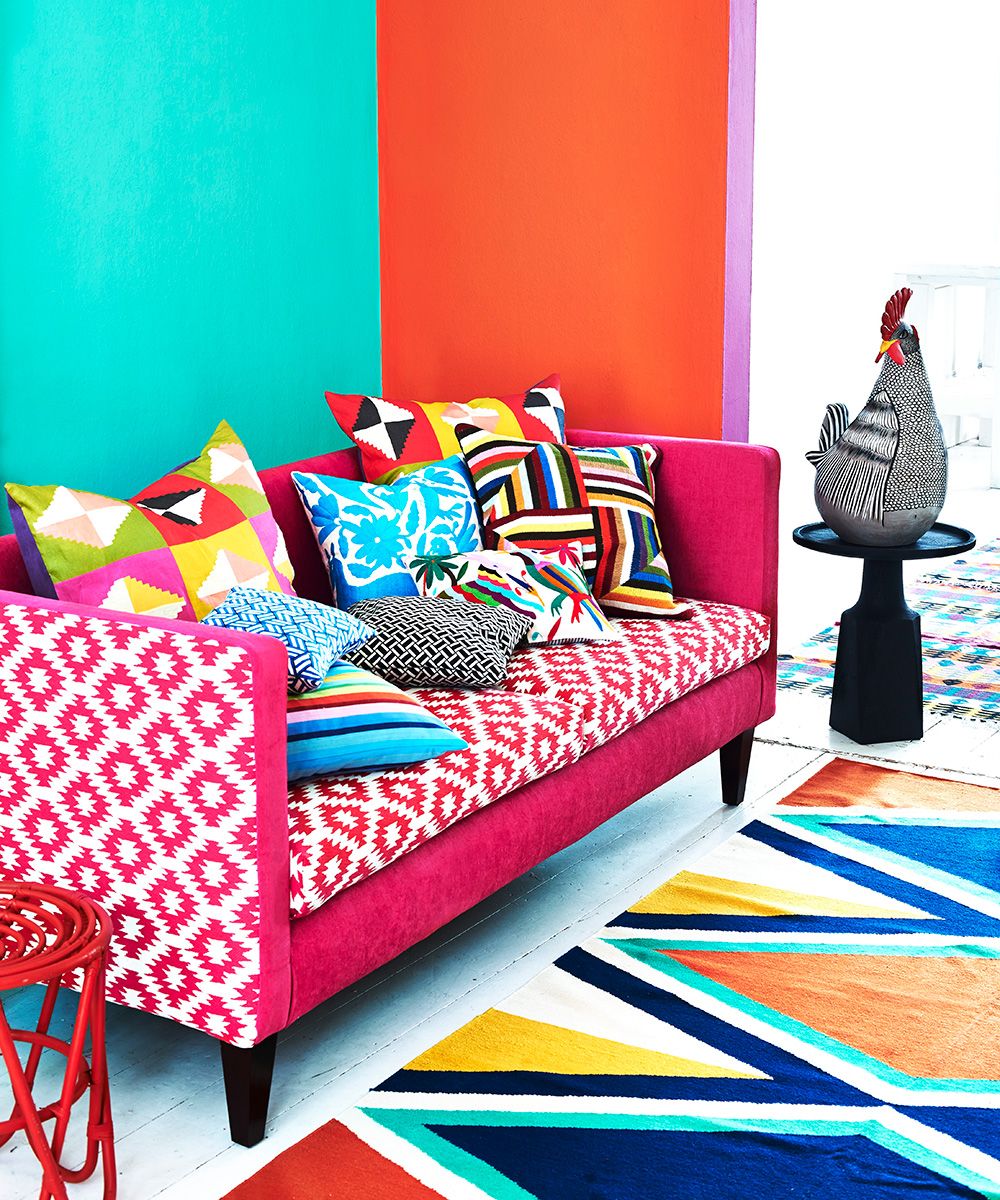 A vibrant, brightly colored living room with patterned sofa and cushions.