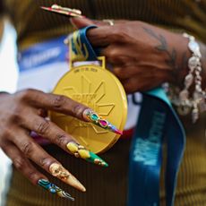 shacarri richardson with nail art holding an olympic gold medal