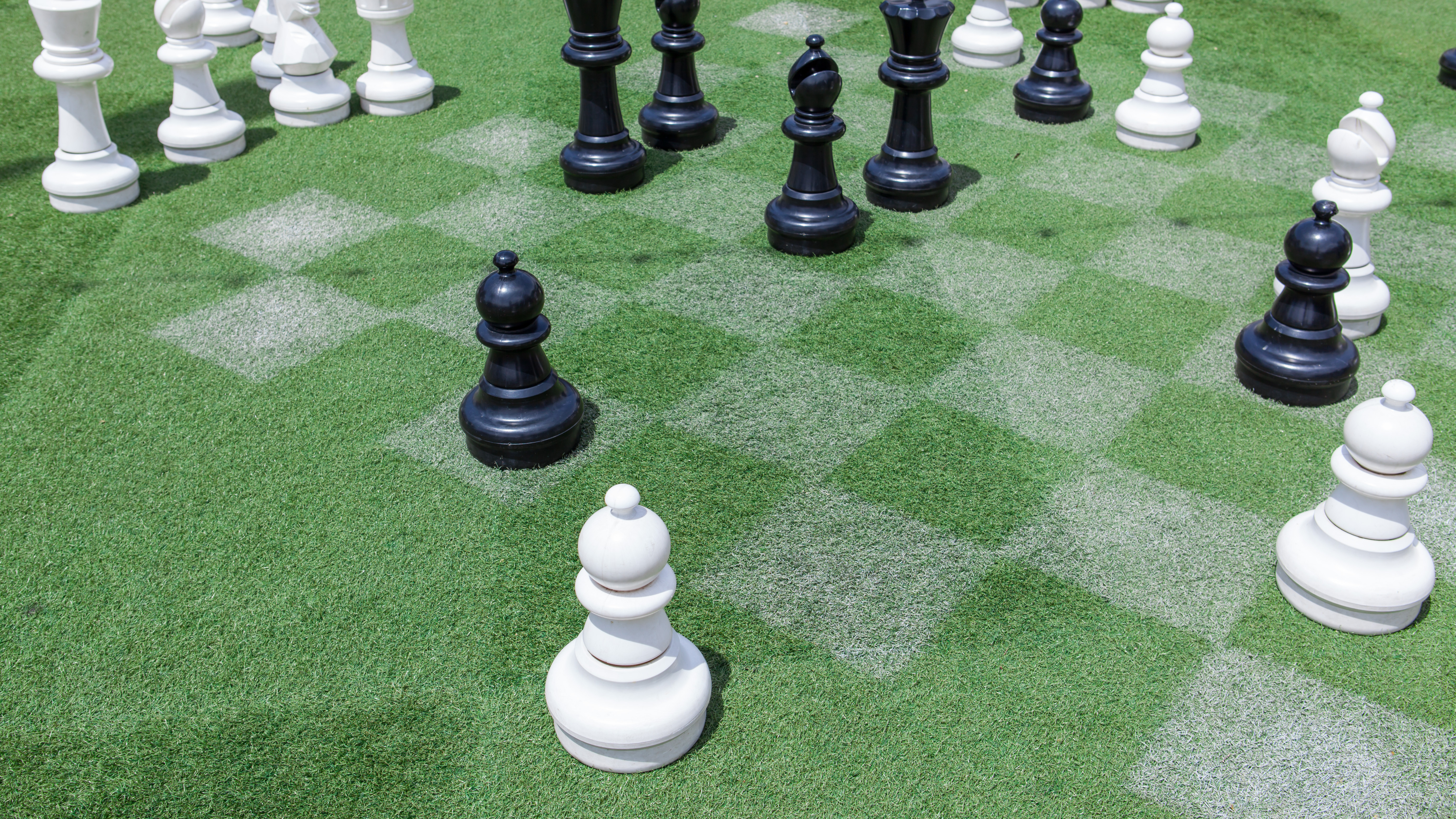 Chess pieces on checkerboard lawn