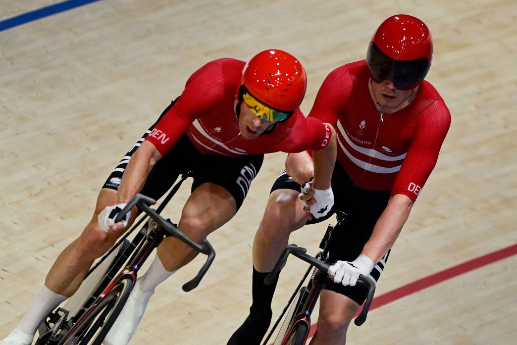 Denmark's Niklas Larsen and Denmark's Michael Moerkoev relay as they compete in the men's track cycling madison final of the Paris 2024 Olympic Games at the Saint-Quentin-en-Yvelines National Velodrome in Montigny-le-Bretonneux, south-west of Paris, on August 10, 2024. (Photo by John MACDOUGALL / AFP)