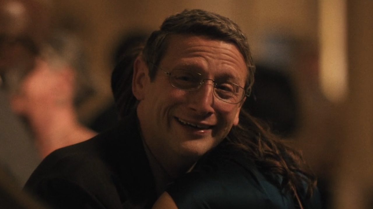 Ron smiling and crying while looking at himself in the mirror in The Chair Company Episode 7