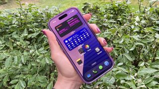 iPhone 16 Pro in hand, dark mode