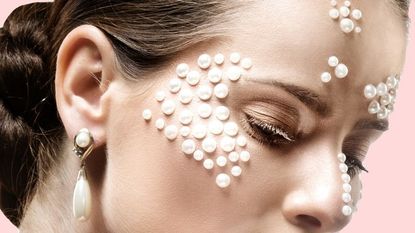 A woman with pearls glued to her face in a pattern.