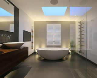 A white free-standing bath with LED lighting on either side