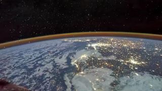 Photograph of Earth's curvature as viewed from spacecraft, with yellow lights twinkling across Africa..