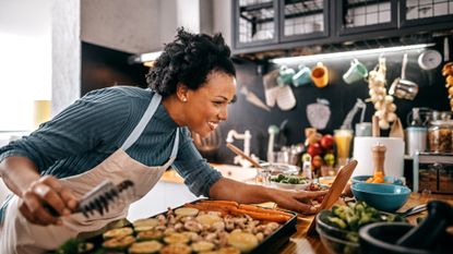 Woman using a vegan cookbook to make a meal