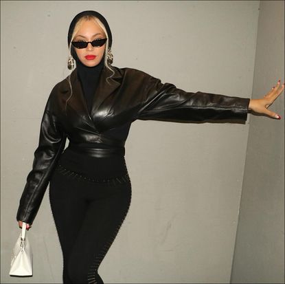 Beyonce in black leggings, leather jacket, and hooded Alaia top