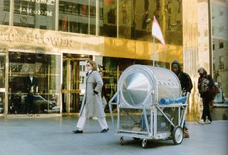 Colour photograph by Krzysztof Wodiczko of a woman walking outside the golden Trump Tower in New York
