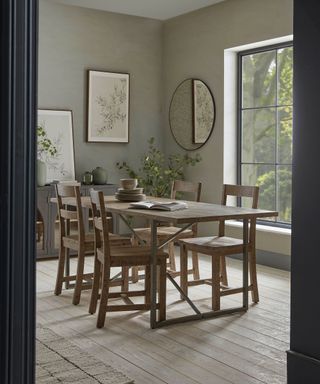 grey dining room with rectangular wooden table and large sash window