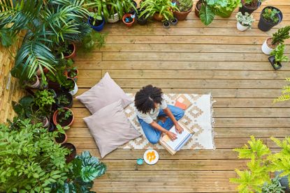 Wellness tips: Portrait of woman sitting in her garden using a laptop