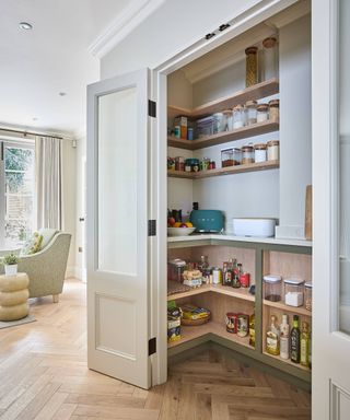 small walk in pantry with open shelving and wooden floor