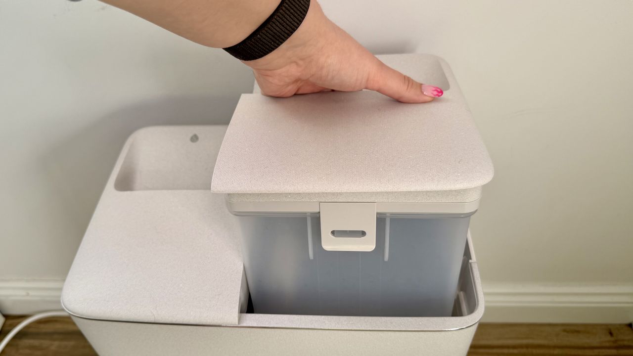 Hand holding Ecovacs clean water tank