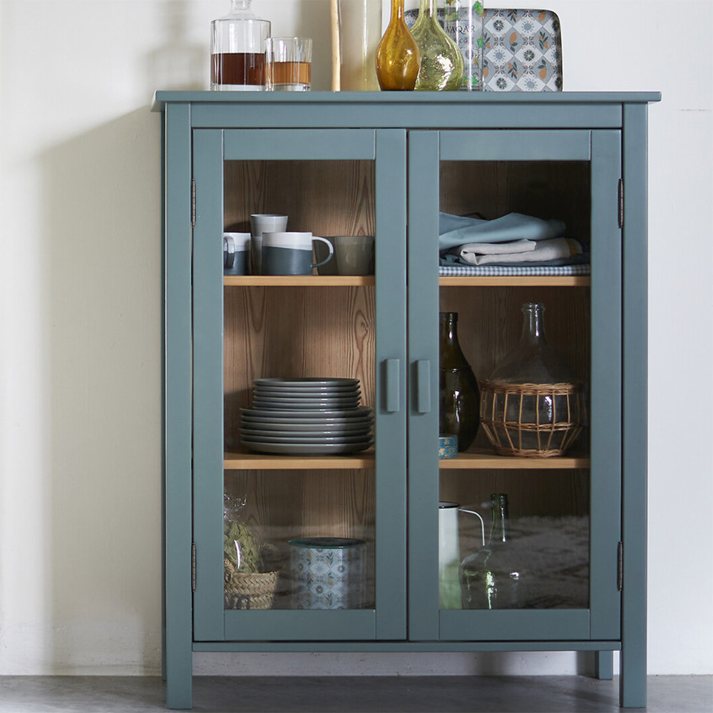 Blue painted cabinet filled with dining room essentials