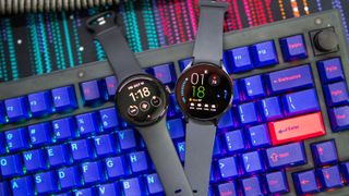 Google Pixel Watch vs Samsung Galaxy Watch 5 laying on keyboard