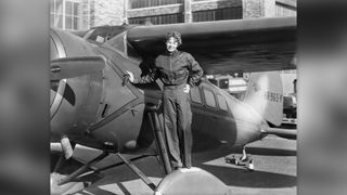 Amelia Earhart (1898-1937), American aviatrix, first woman to cross Atlantic. Photograph showing her with airplane.