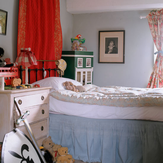 bedroom with grey wall bed with white cushion white drawers and curtains