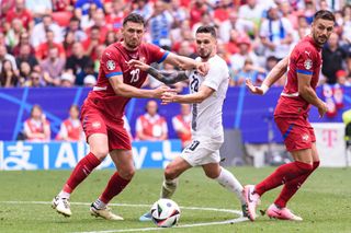 Milos Veljkovic of Serbia (L) fights for the ball with Petar Stojanovic of Slovenia (C) during the UEFA EURO 2024 group stage match between Slovenia and Serbia at Munich Football Arena on June 20, 2024 in Munich, Germany.