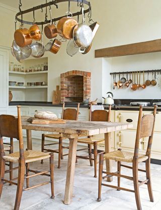 French country kitchen with rustic table and chairs with cream painted walls