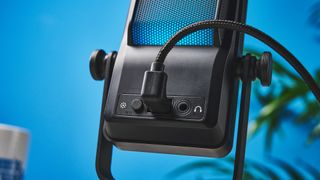 a small retro-inspired microphone with a large RGB sound capsule is photographed against a blue background