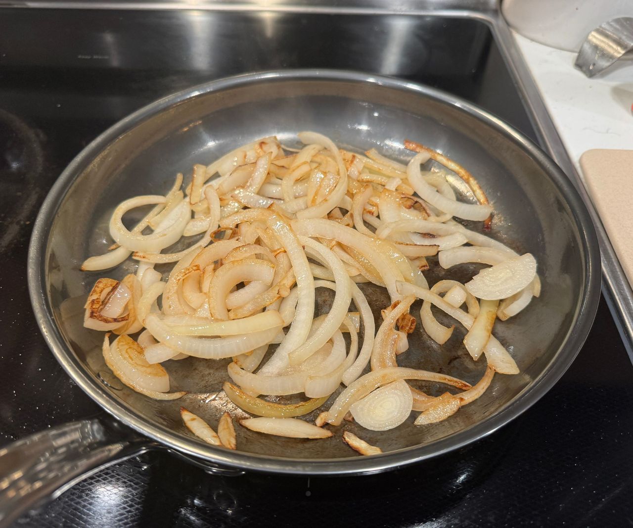 The Hestan NanoBond Skillet with browning onion slices inside.