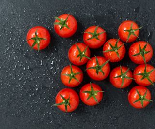 A selection of harvested tomatoes on a slate board in a kitchen
