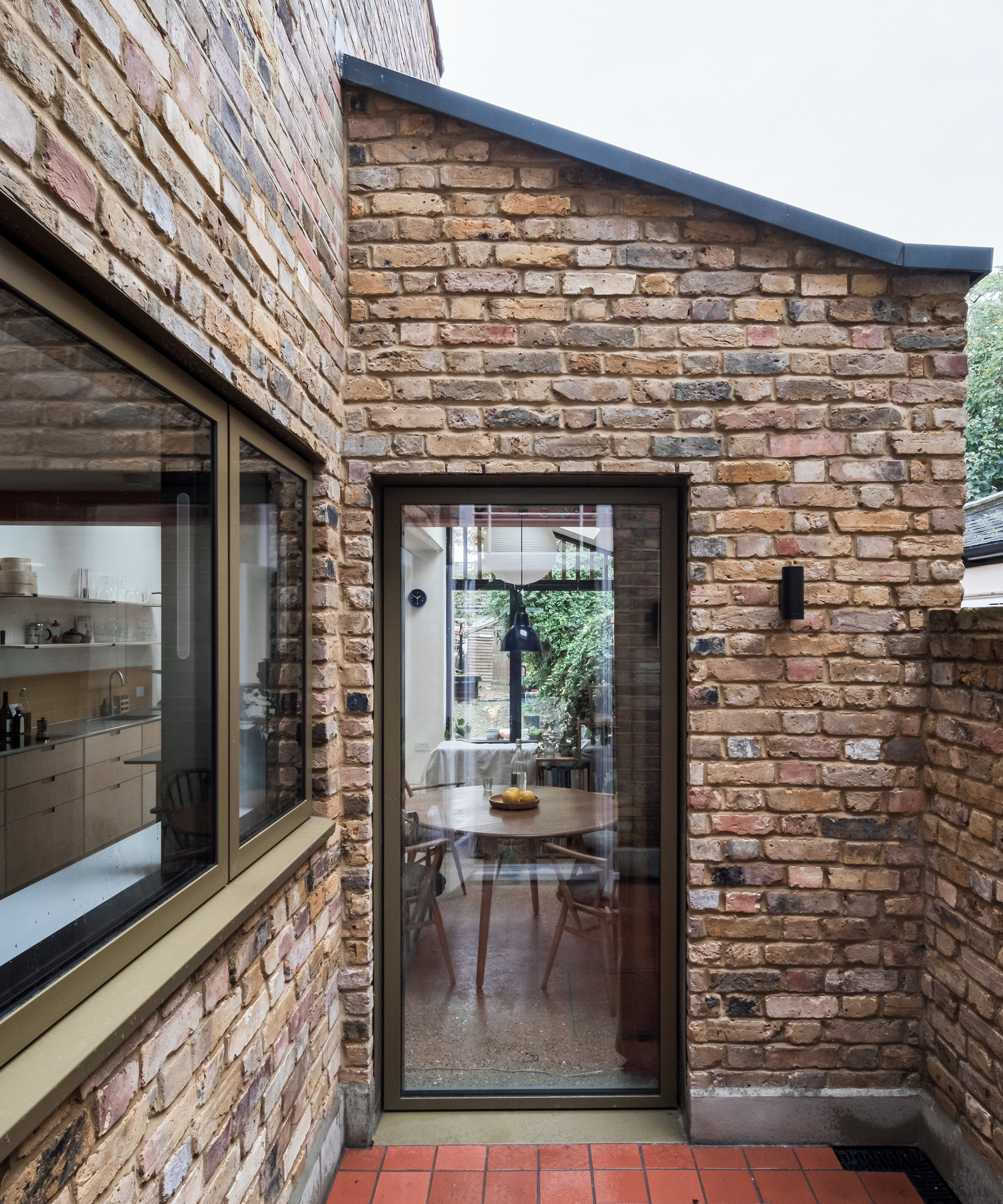 An interior courtyard in a ground floor rear extension project. The exterior walls are light brick and the floor is terracotta
