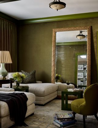 green interior with chartreuse trim, gold mirror, beige sofa, and rug