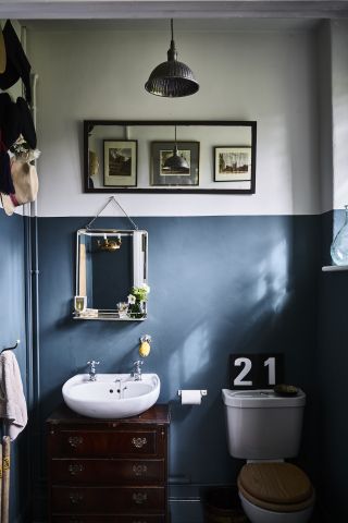 A white and blue bathroom in a period property with a white sink and a 21 sign above the toilet