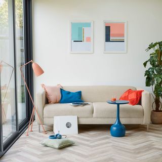 wood flooring, white sofa with colourful cushions and bright accessories