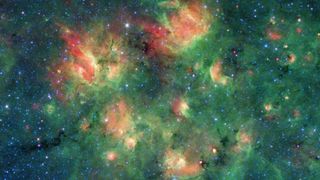 In a new image from NASA's Spitzer Space Telescope, giant "bubbles" of dust and gas are bursting with new star formation. According to NASA, each of these bubbles contains hundreds of thousands of stars. These cosmic bubbles get their shape from stellar winds radiation emitted from massive young stars, which can push the cloud's material outward, causing it to "inflate," or expand.