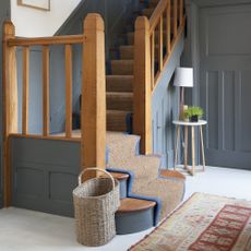 modern country style entrance hall with stairs with runner and wooden bannisters