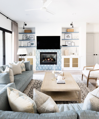 Blue and white living room with cozy, modular couch and light wooden coffee table in the centre