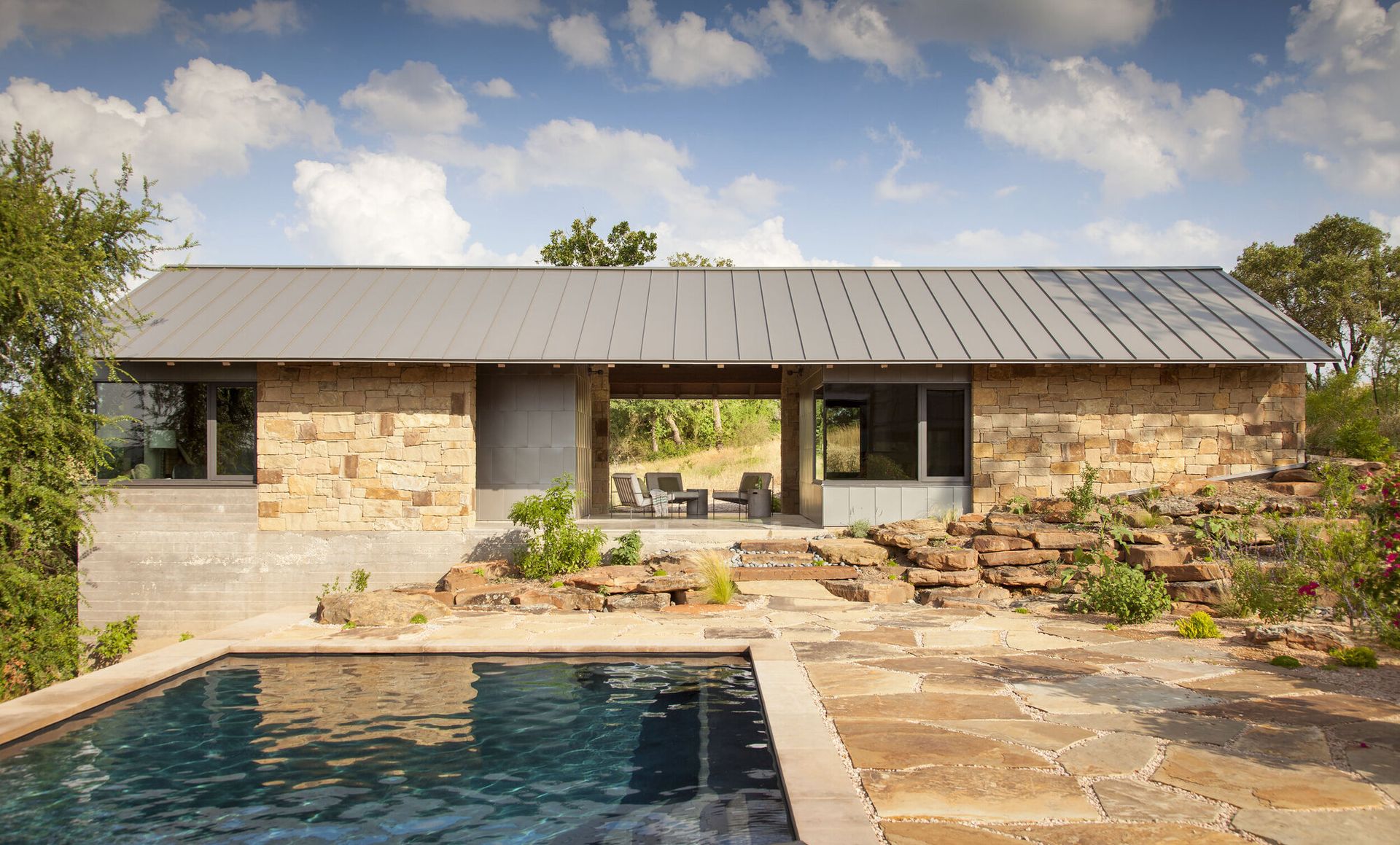 A natural pool with surrounding deck that mirrors the landscape