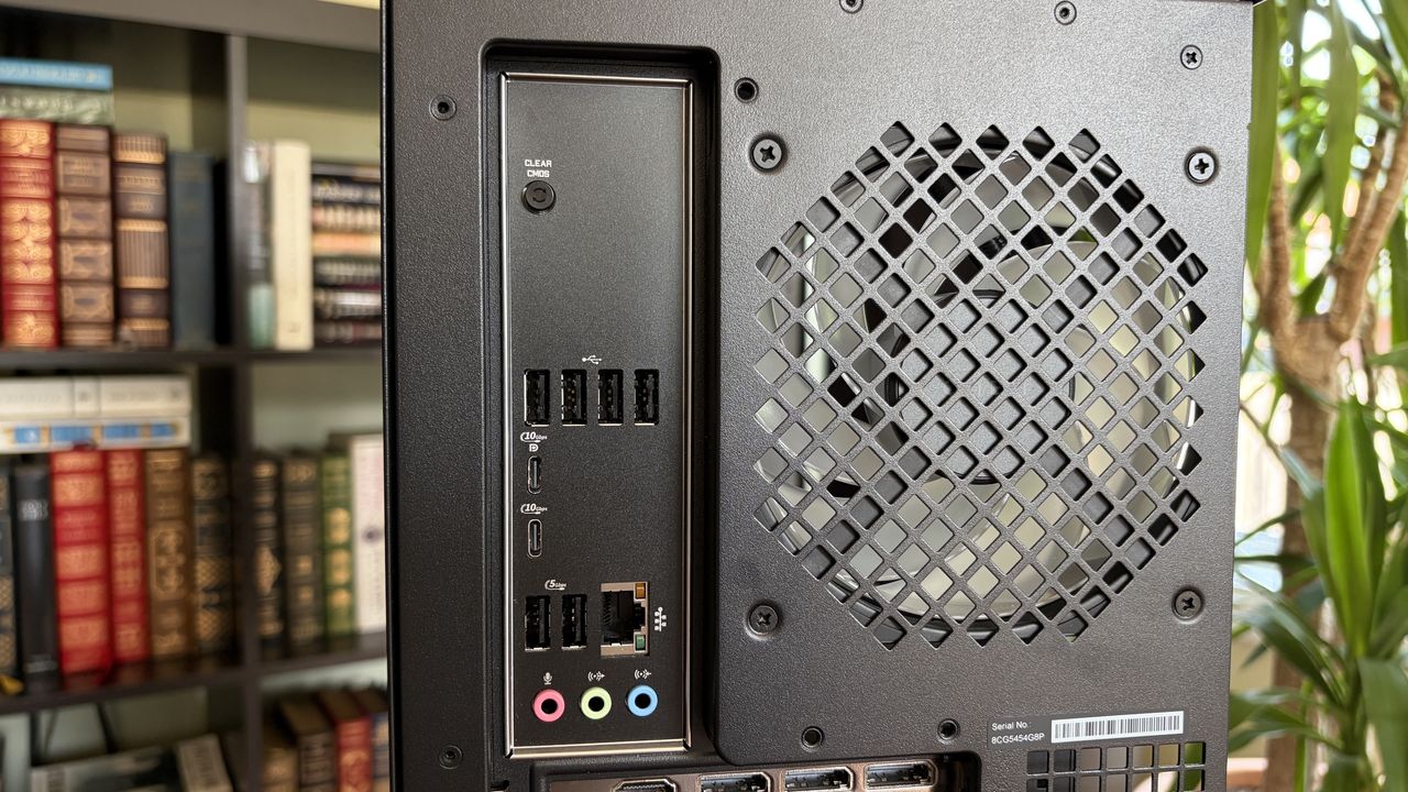Rear view of an Omen Max 45L computer tower with multiple USB ports, an Ethernet port, audio jacks, and a ventilation grille, set against a blurred bookshelf background.