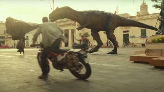 Chris Pratt riding a motorbike near large dinosaurs in Jurassic World: Dominion.