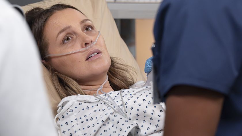 Camilla Luddington as Jo Wilson lies in a hospital bed, looking worried in the Grey&#039;s Anatomy Season 22 fall finale.