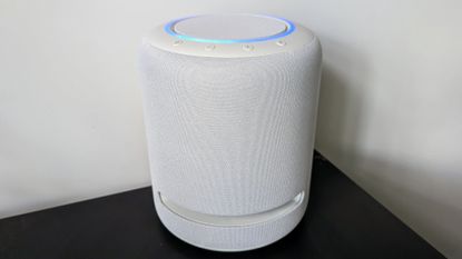 Amazon Echo Studio (2022) review: woman listening to music on a home speaker in a living room