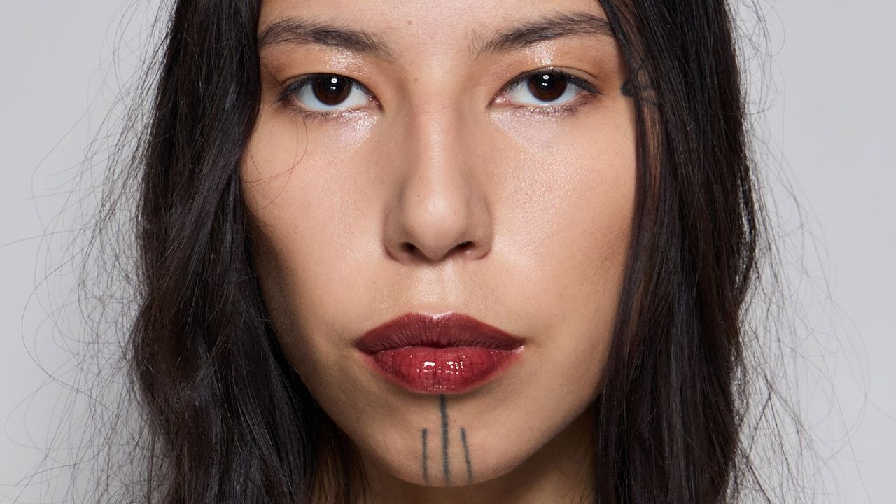 Model backstage wearing a bold, glossy red lip