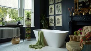 dark blue bathroom with fireplace and rolltop bath