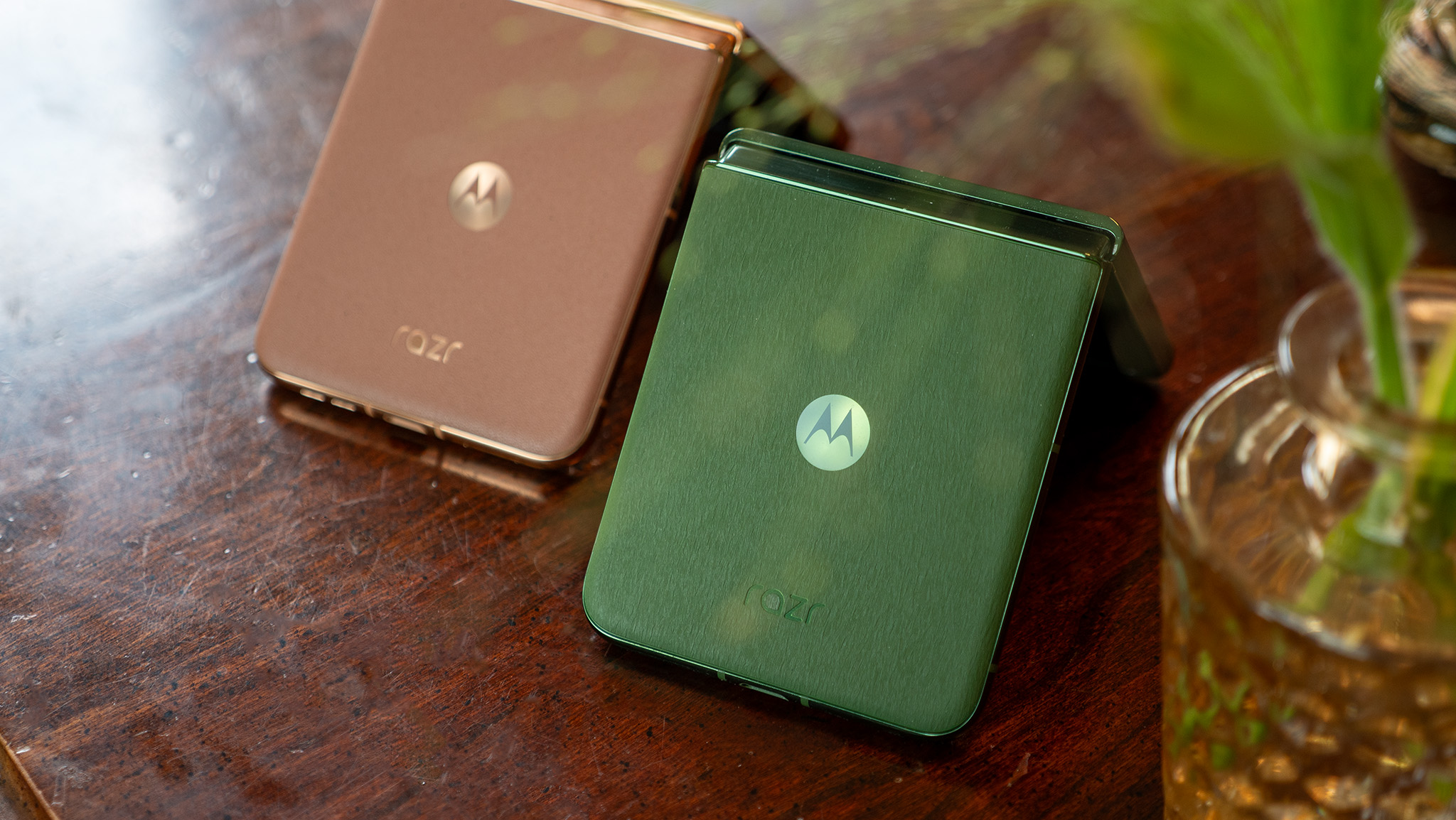 The folded backs of the Motorola Razr Plus 2024 in Green and Motorola Razr Plus 2025 in Mocha