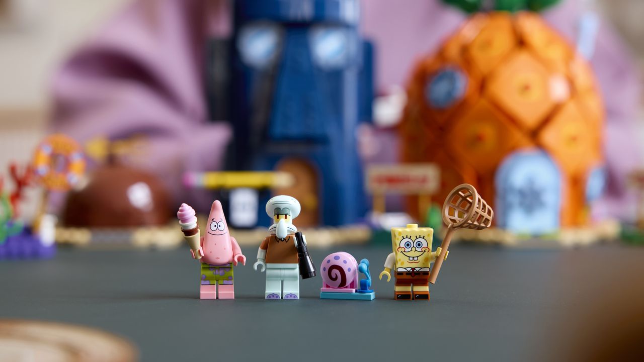 Lego Patrick, Squidward, Gary the Snail, and Spongebob on a gray surface in front of the blurred Bikini Bottom buildings
