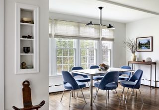 dining room in light colors with blue velvet chairs