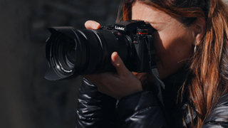 A person holds the LUMIX S1RII, ready to take a photograph