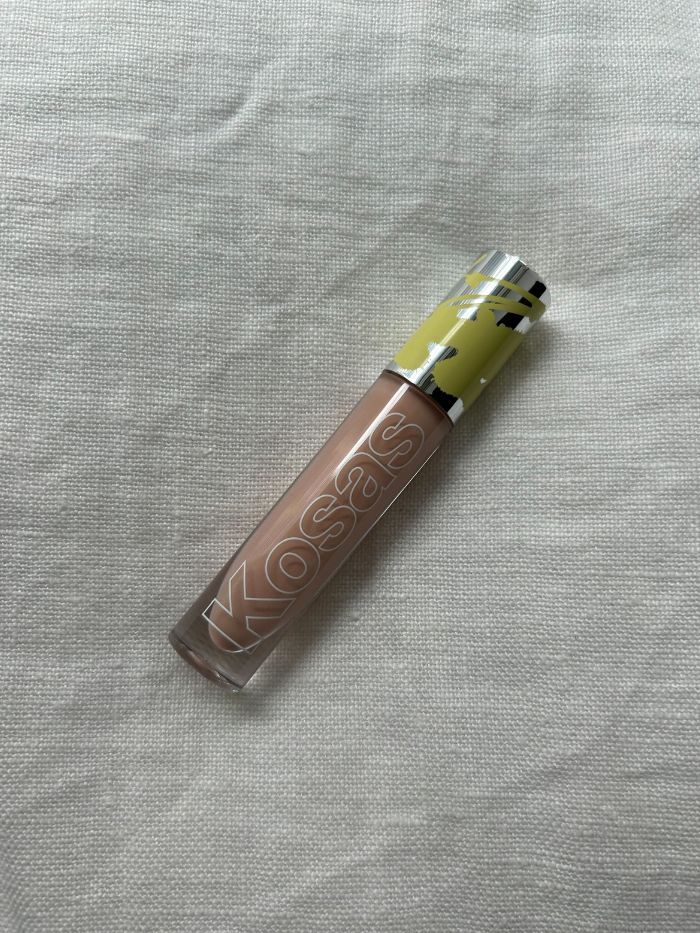 The Kosas Revealer Extra Bright Serum Powered Color Corrector Review on a light linen background