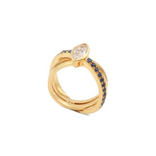 Golden band that twists together and dark stud stones on the outside and an oval diamond on top.