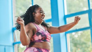 A woman celebrates in the gym