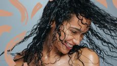 A woman with curly wet hair, about to air dry hair