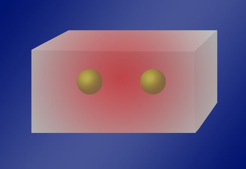 Physicists have found that two or more atoms can absorb a single photon when inside a cavity with standing light waves of a certain frequency (red glow).